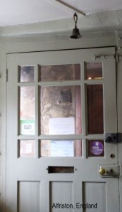 Door with ceiling bell leading out of Alfriston, England cafe